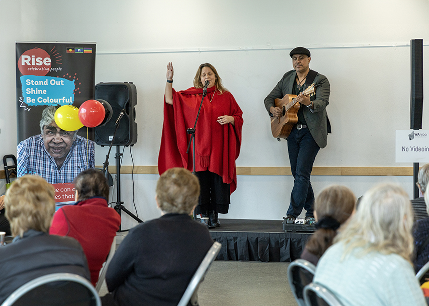 Live performance at Rise’s 2024 NAIDOC celebration featuring a singer and guitarist on stage with seated audiences.